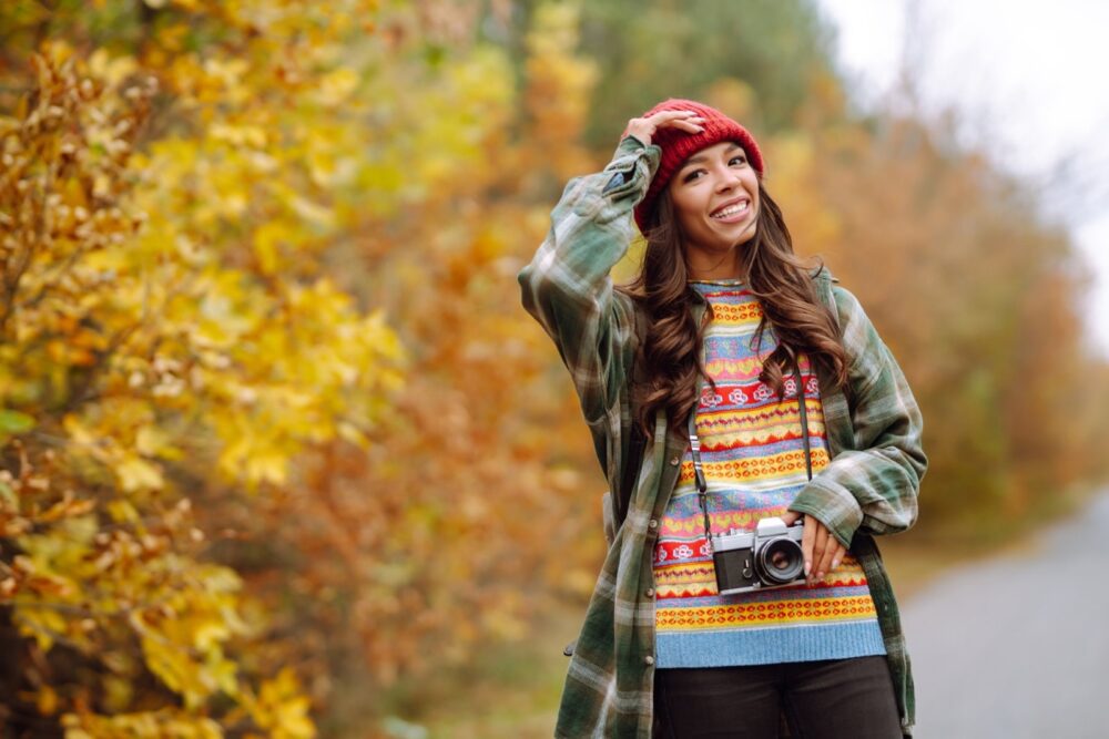 Kaunis noor naine poseerib retrokaameraga. Puhkus, lõõgastus, reisimine, elustiil.
