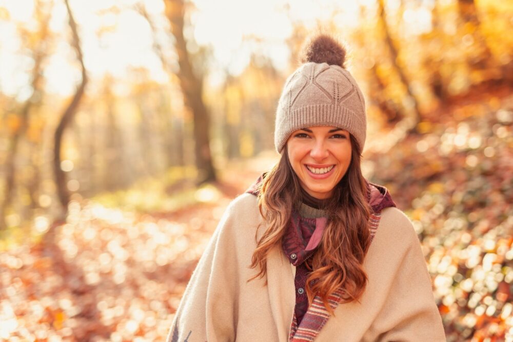 Naine jalutab läbi metsa päikeselisel sügispäeval